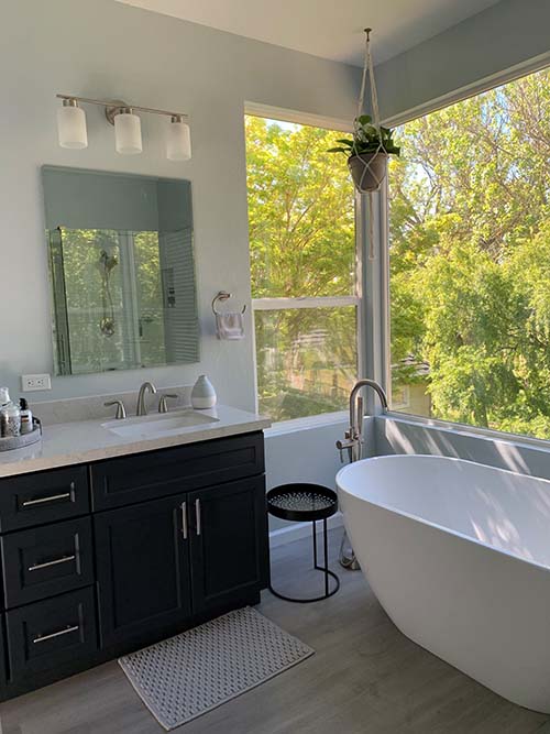 Beautiful remodeled bathroom with elegant tub and windows