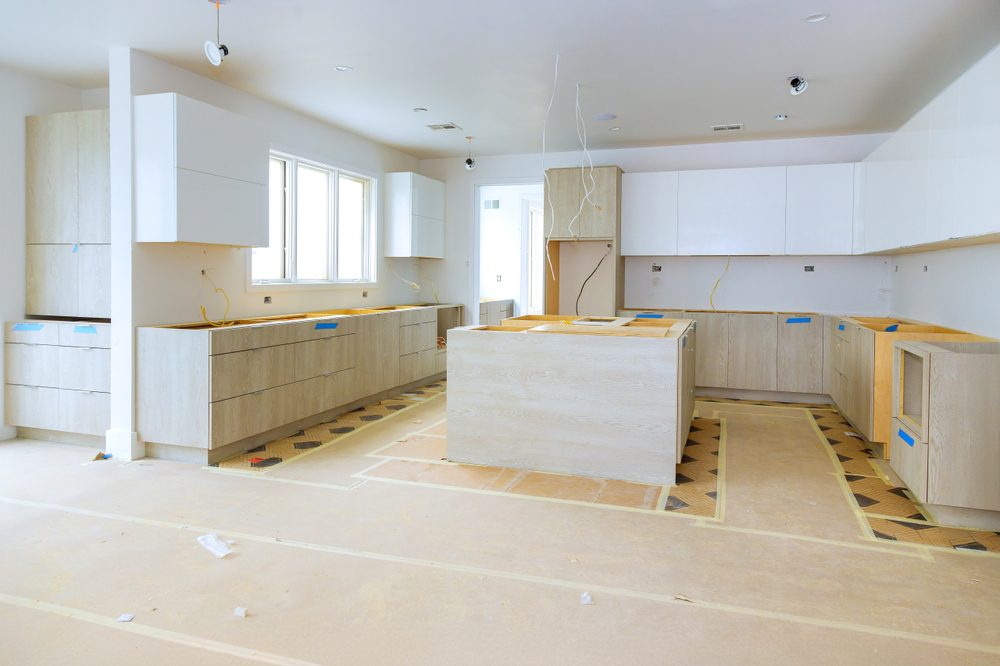 New custom kitchen during construction process with cabinets and flooring installed.