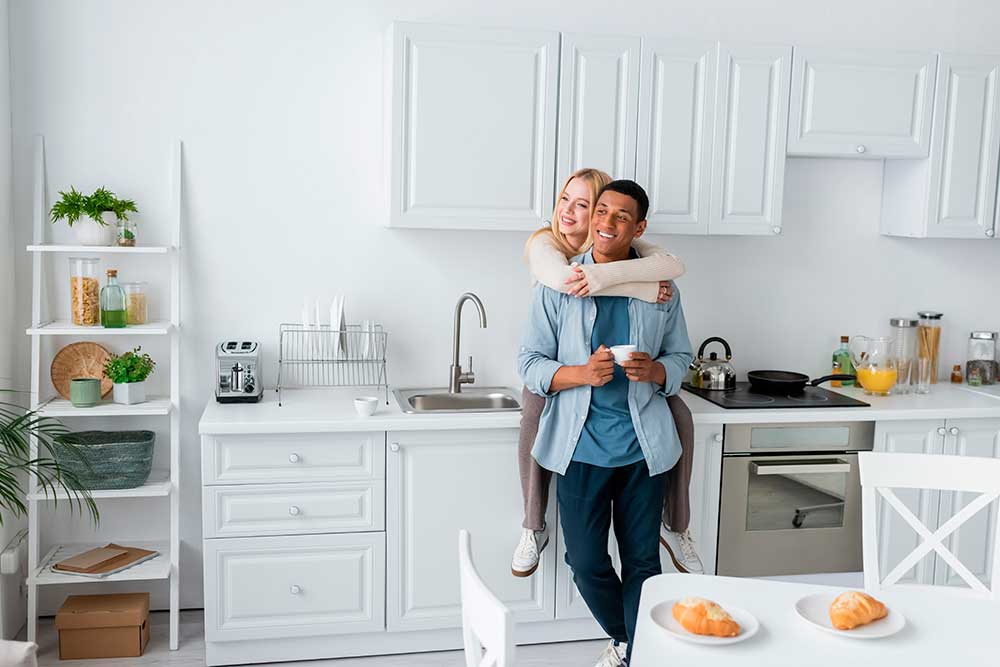 happy-couple-in-kitchen Man and woman hugging and happy in their newly remodeled kitchen