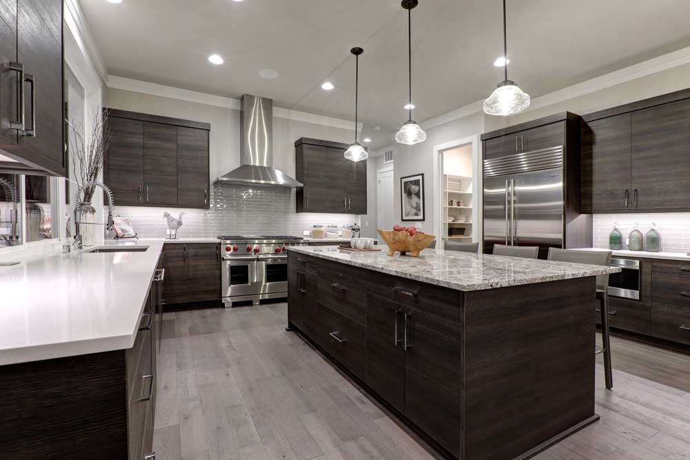 Modern gray kitchen features dark gray flat front cabinets paired with white quartz countertops and a glossy gray linear tile backsplash.